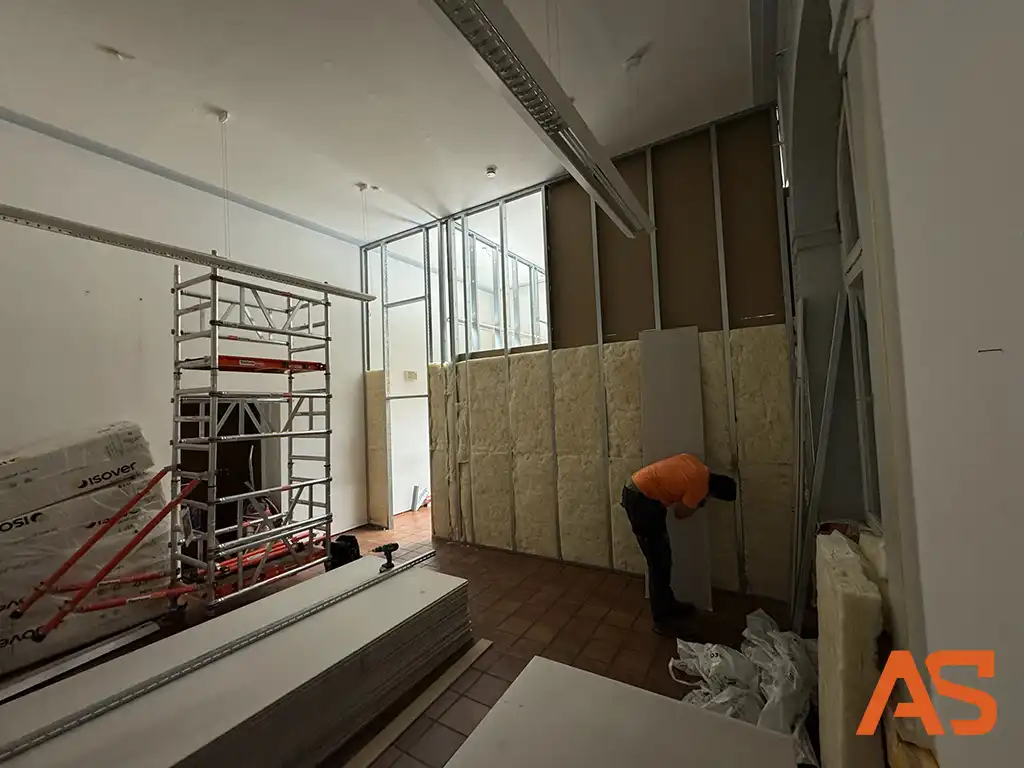 Schallschutz-Maßnahmen: Einbau von Mineralwolle-Dämmung in die Trennwand für akustische Ruhe im Büro.