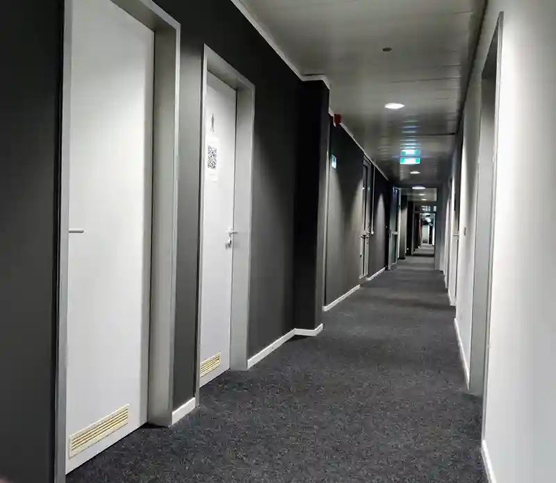 Empfangsbereich mit Sofa und moderner Beleuchtung in einem sanierten Münchner Büro.