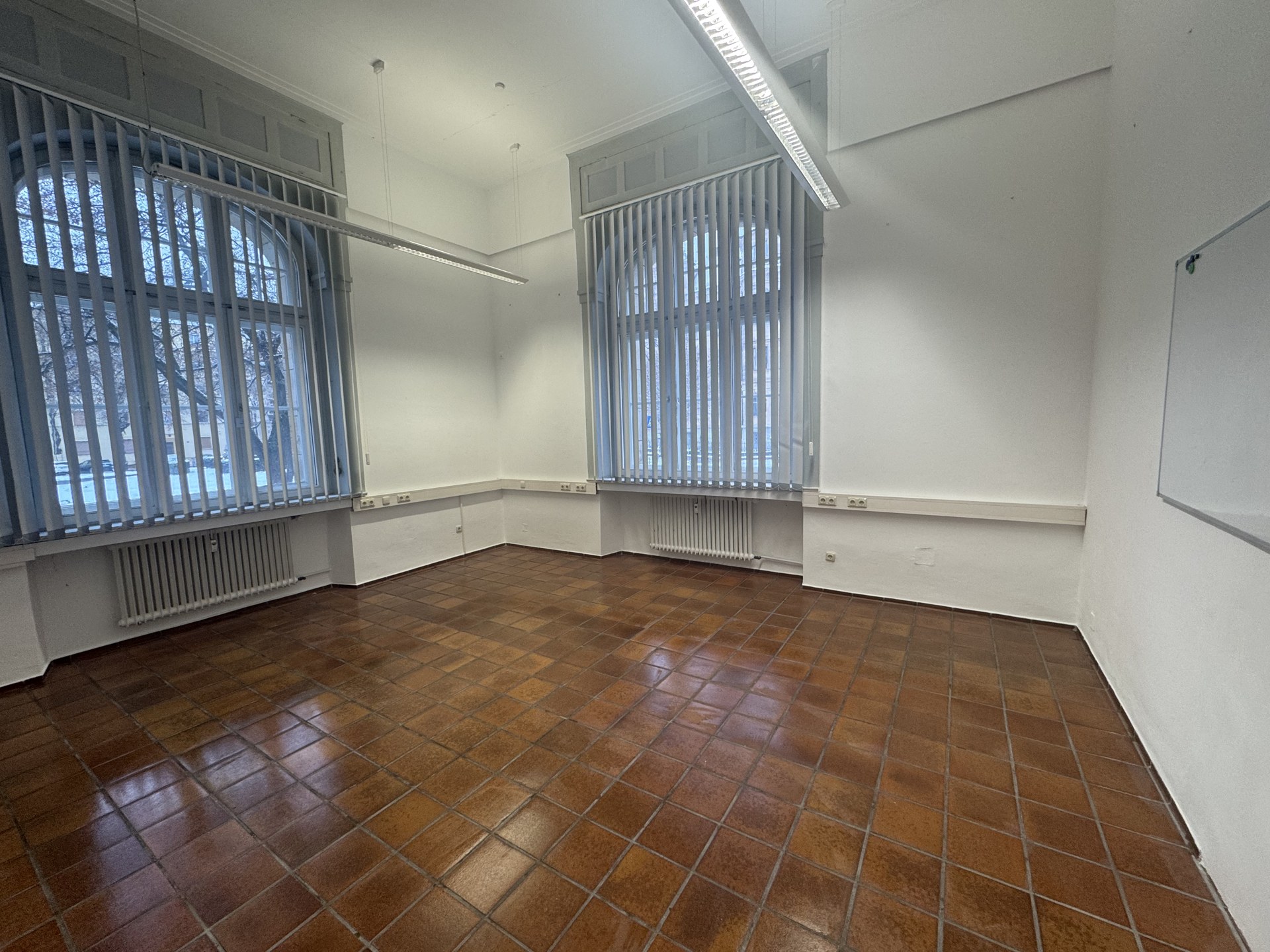 Fertiger Schulungsraum mit voller Raumhöhe, freien Fensterachsen und Q4-Oberflächen.