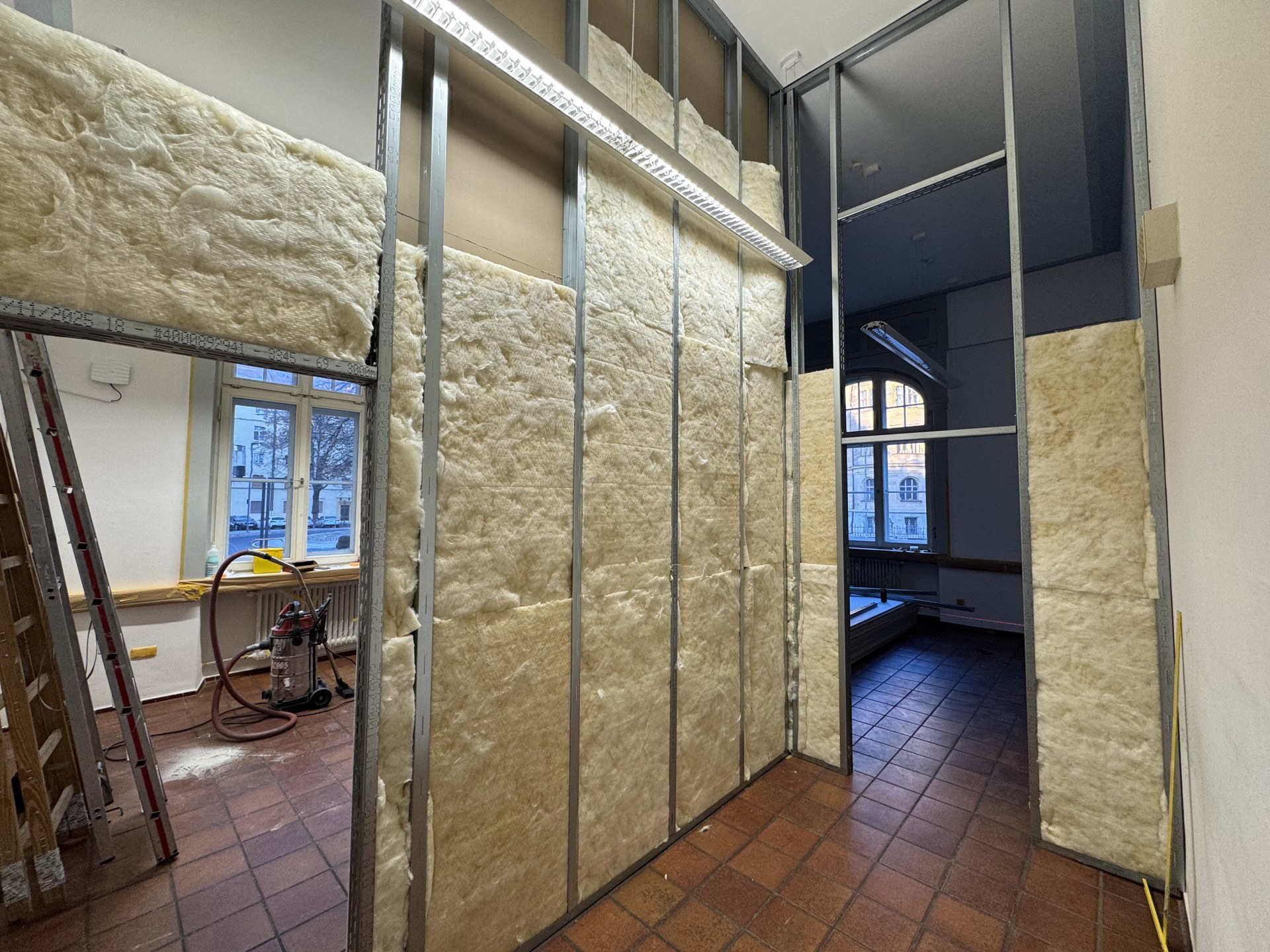 Einbau der Mineralwolle in das Ständerwerk — Schallschutz zwischen Schulungsraum und Lehrküche.